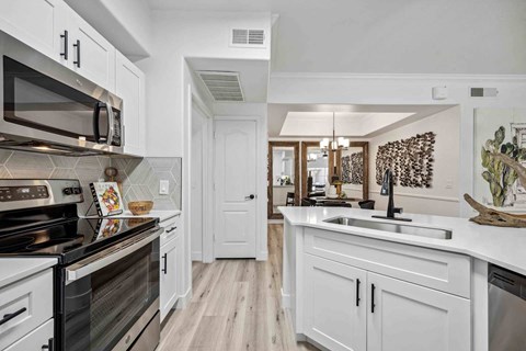 A kitchen with white cabinets and a black stove top oven.