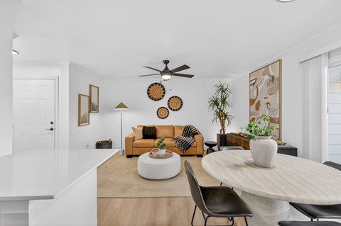 A living room with a yellow couch and a white coffee table.