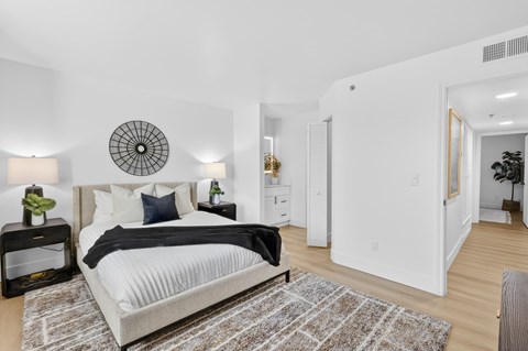 A bedroom with a large bed and a round decorative item on the wall.