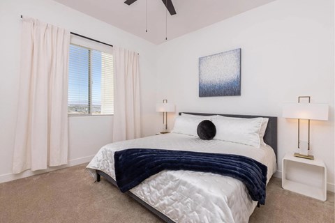 A bedroom with a large bed and a ceiling fan.