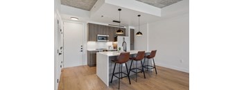 a kitchen with a large island with three bar stools