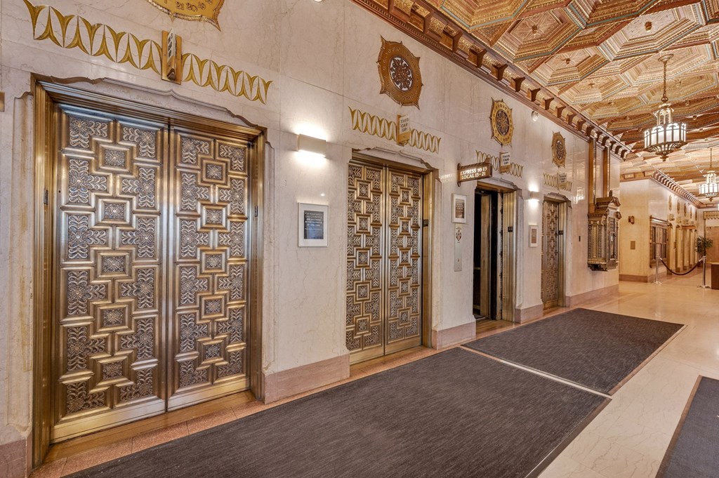 the lobby of a building with doors and a rug