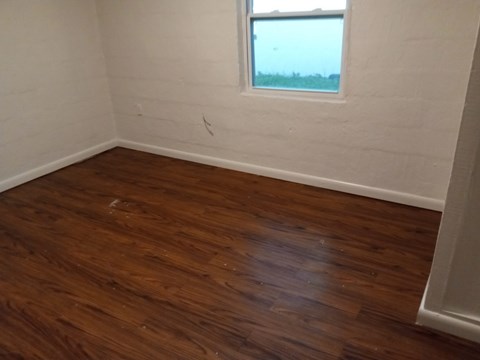 A room with wooden flooring and a window.