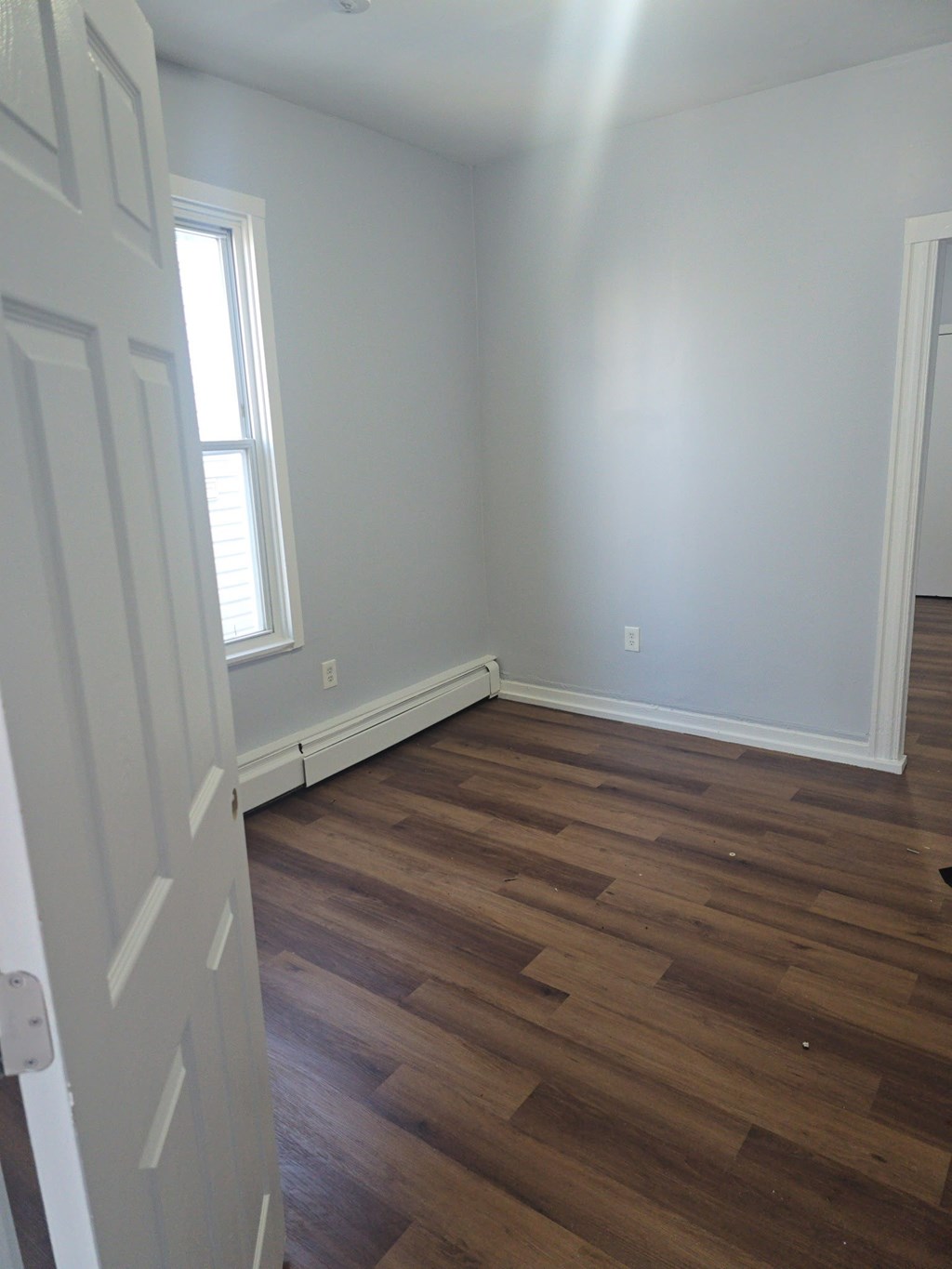 A room with wooden floors and a white door.