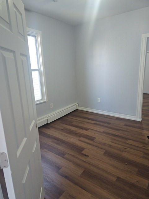 A room with wooden floors and a white door.