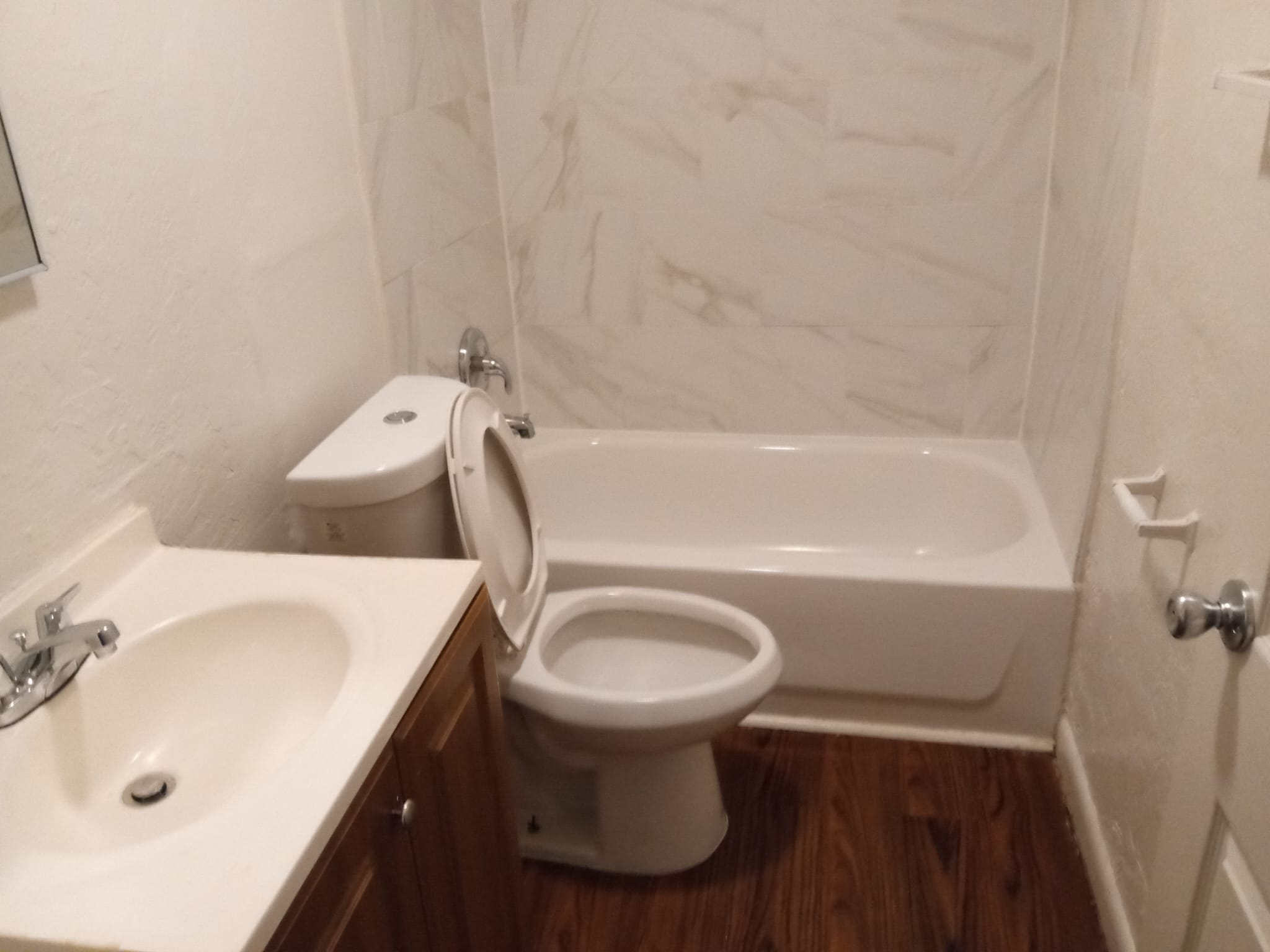 A white toilet sits next to a white sink in a bathroom.