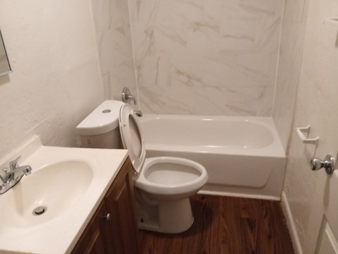 A white toilet sits next to a white sink in a bathroom.