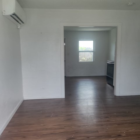 A room with a wooden floor and a window.