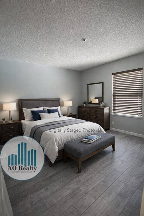 A bedroom with a bed, nightstand, and a mirror on the wall.