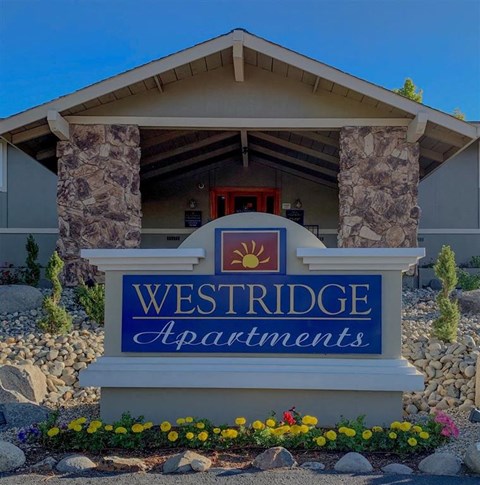 A sign for Westridge Apartments is displayed in front of a building.