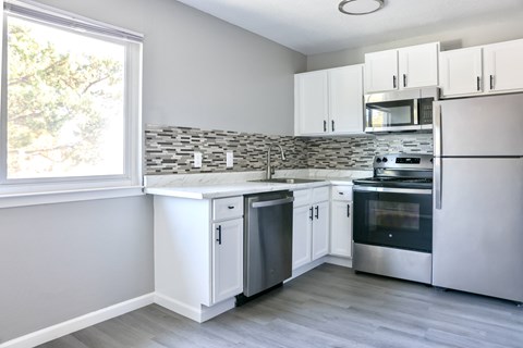 A kitchen with white cabinets and stainless steel appliances.