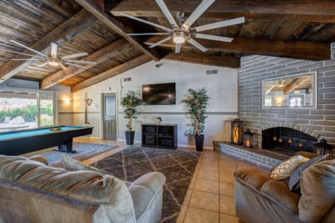 A living room with a pool table and a fireplace.