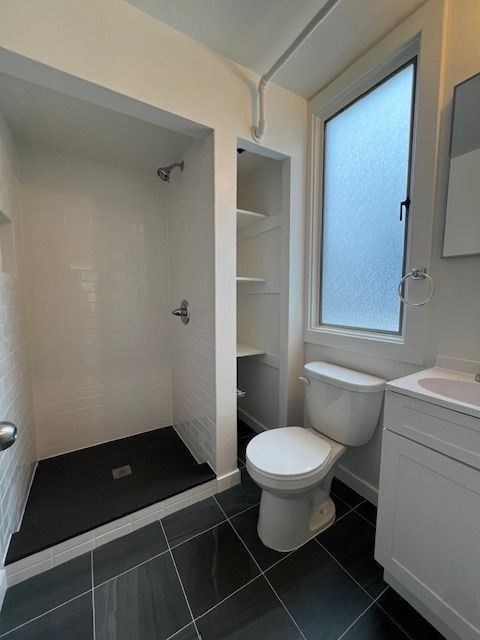A white toilet sits next to a sink in a bathroom.