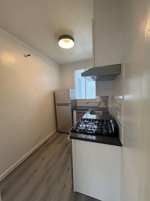 A small kitchen with a refrigerator, stove, and oven.