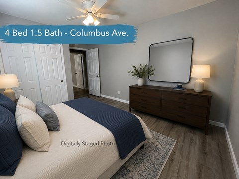 A bedroom with a bed, dresser, and mirror.