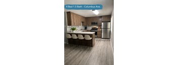 A kitchen with a bar stool and a refrigerator.