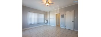 A room with a ceiling fan and a window with blinds.