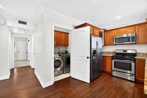A kitchen with a white refrigerator, stove, and microwave.