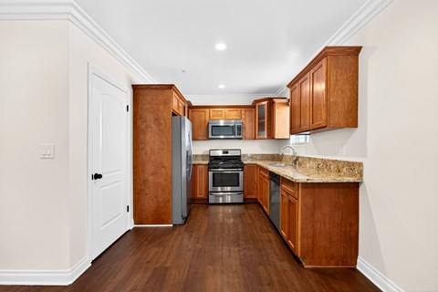 A kitchen with wooden cabinets and a granite countertop.