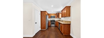 A kitchen with wooden cabinets and a granite countertop.