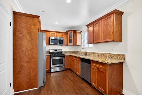 A kitchen with wooden cabinets and a granite countertop.