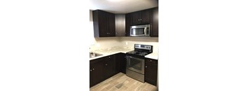 A kitchen with a stove top oven and microwave above it.