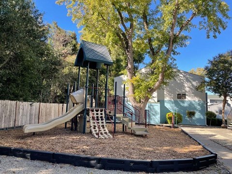 A playground with a slide, swings, and a climbing frame.