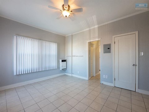 A room with a ceiling fan and a window with blinds.