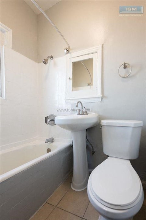 A white toilet sits next to a sink in a bathroom.