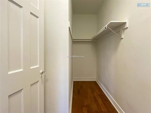 A white door is on the left and a white shelf is on the right.