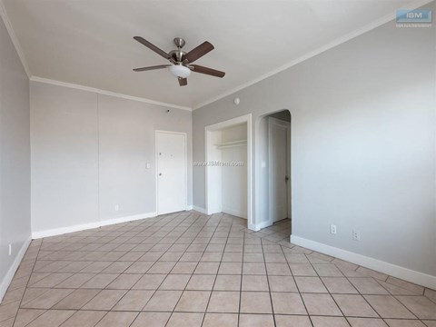 A room with a ceiling fan and tile flooring.