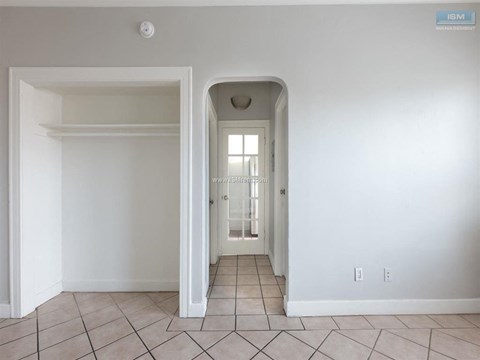 A white room with a doorway leading to another room.