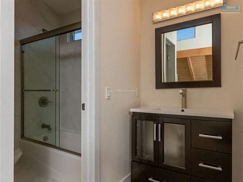 A bathroom with a mirror and lights above it.