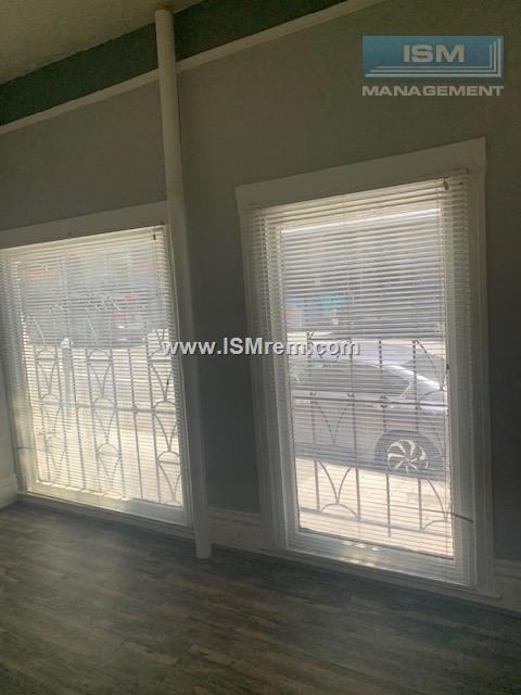 A room with a window showing a car and a building outside.