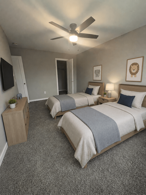 A bedroom with two beds and a ceiling fan.
