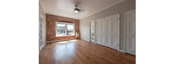 A room with a brick wall and wooden floors.