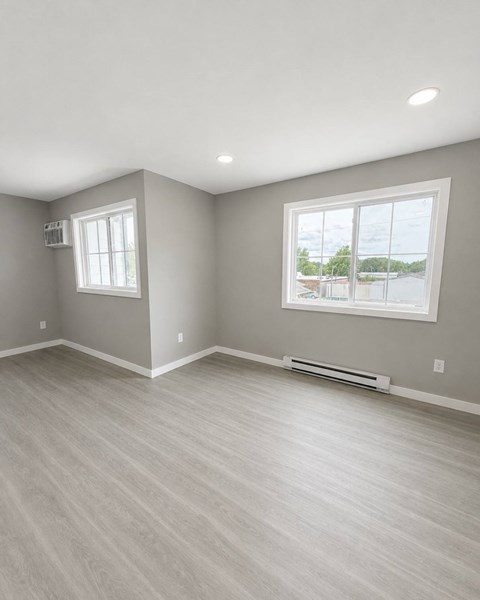 A room with a window and a wall-mounted air conditioner unit.