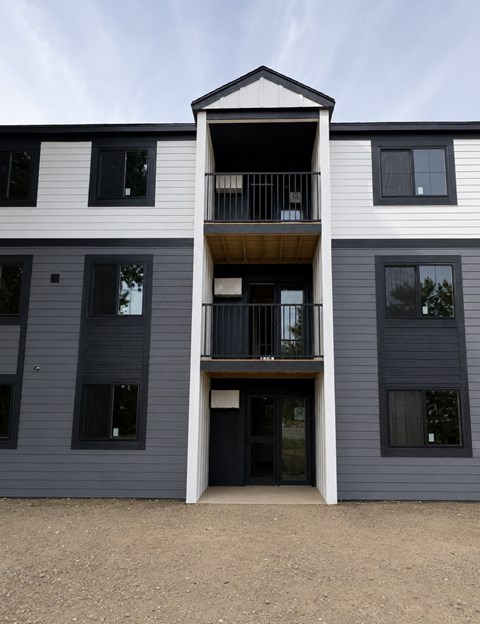 A modern two-story building with a balcony on the second floor.
