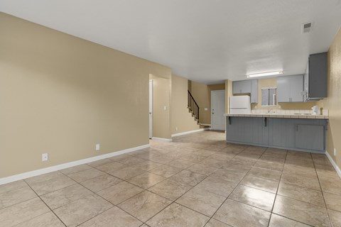 A spacious room with beige walls and a tiled floor.