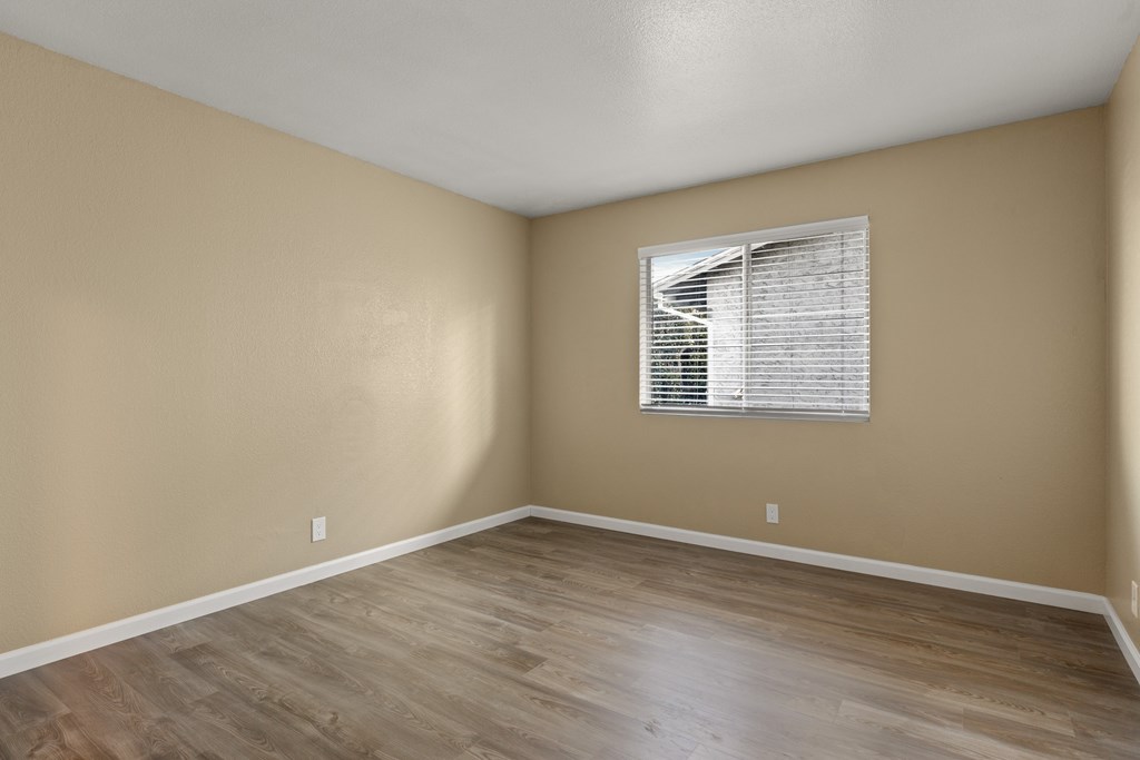 A room with a window and wooden flooring. at Cedar Park Apartments, Chico, California