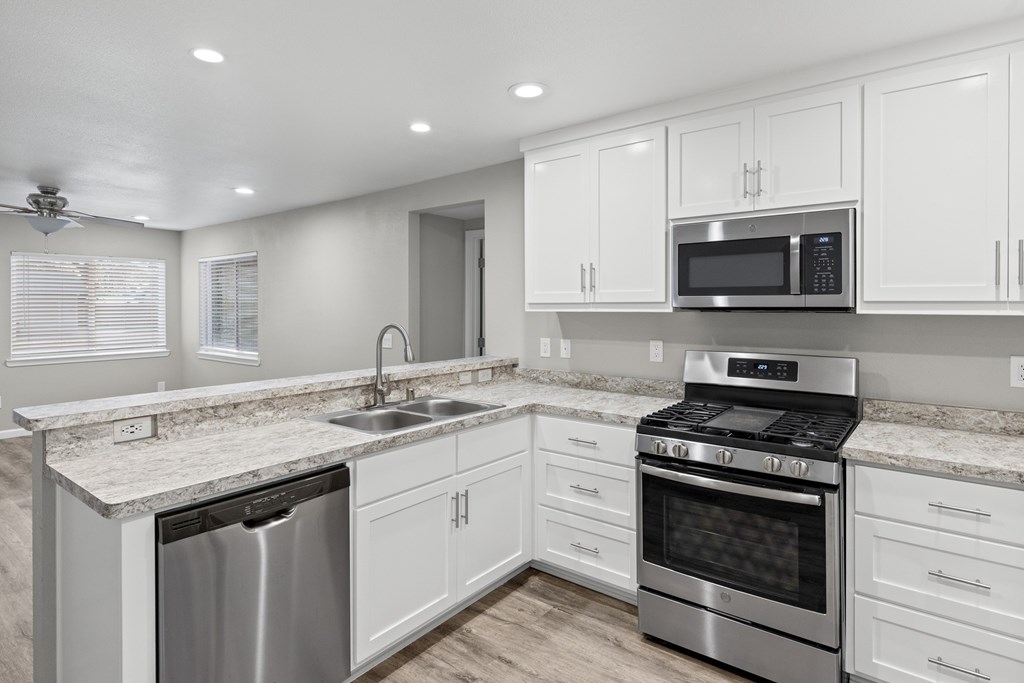 A modern kitchen with white cabinets and stainless steel appliances. A modern kitchen with white cabinets and stainless steel appliances.at OSM Properties Homes & Apartments, Chico, CA