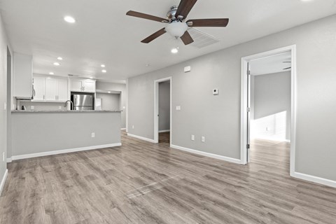 A spacious room with a ceiling fan and lighting fixtures.