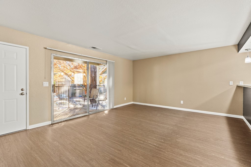 A room with a sliding glass door leading to a backyard.at Redwood Cove Apartments, Chico  