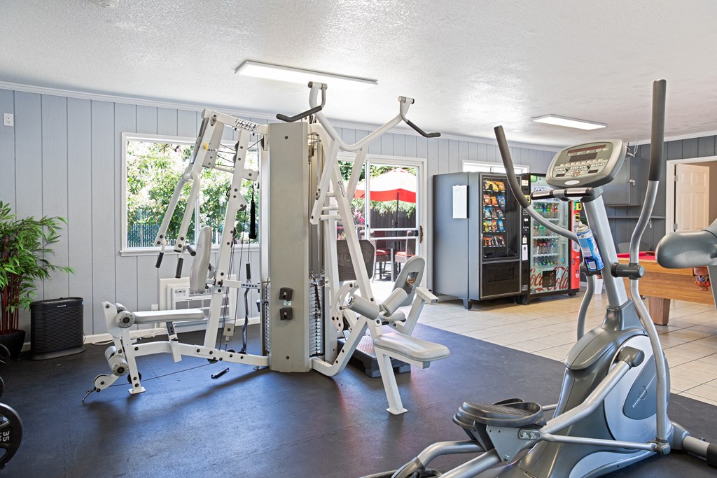 a gym with weights and cardio equipment in a home gym a gym with weights and cardio equipment in a home gym at Creekview Homes, Chico