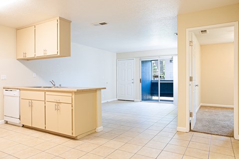 A kitchen with beige cabinets and a white dishwasher.