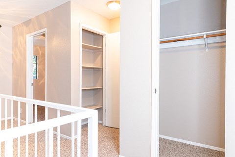 Upstairs hallway with closets and carpeted flooring at Pomona Townhomes Apartments, Chico, CA 95928