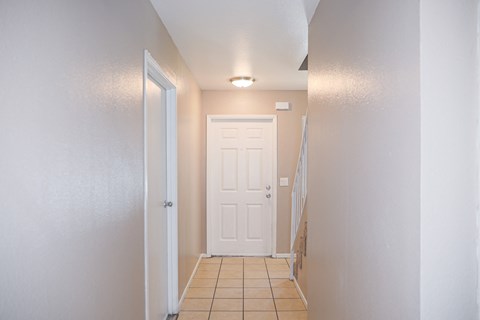 Entry hallway with tile flooring and front door at Pomona Townhomes Apartments, Chico, CA