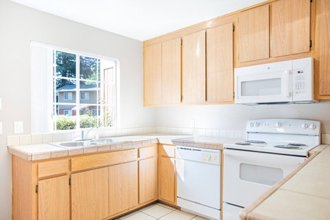 A kitchen with wooden cabinets and white appliances.