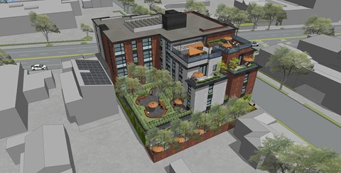 A modern building with a green roof and a parking lot in front.