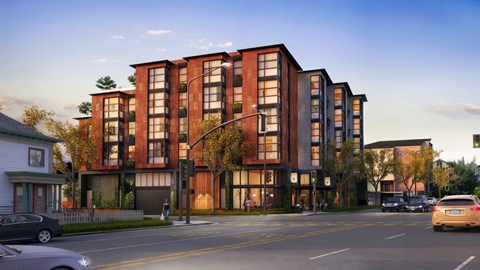 A modern apartment building with a red brick facade and large windows.